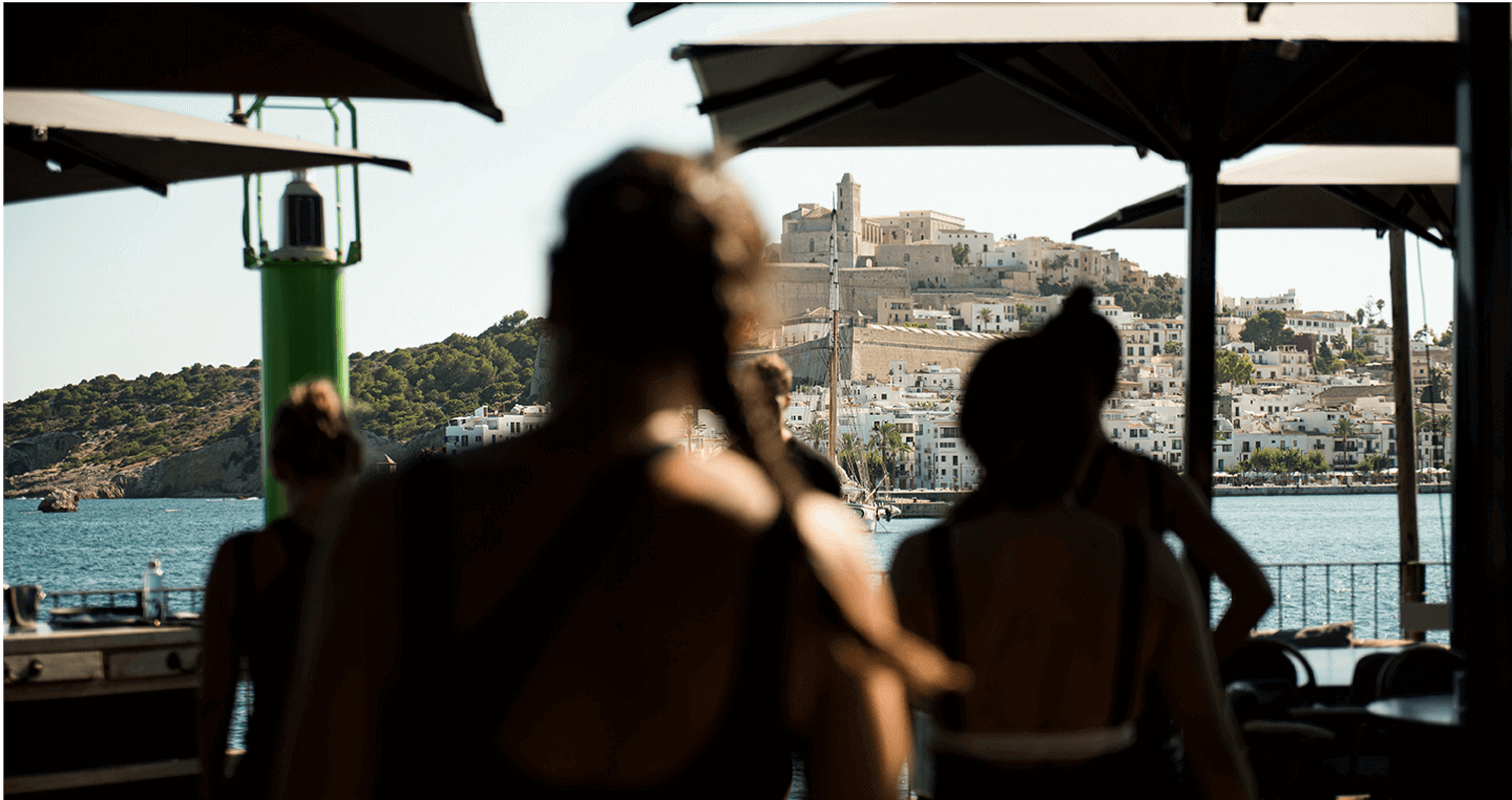 Group of people exercicing in a terrace with great views of a city in an island